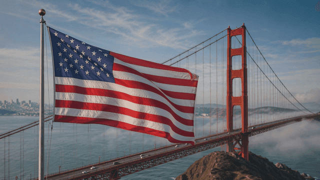 American flag fluttering near suspension bridge