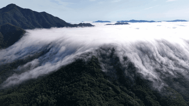 Clouds rolling over lush green mountains