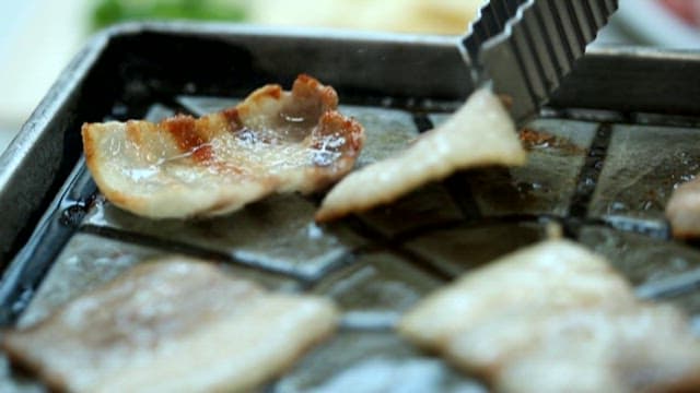 Sizzling pork belly on a hot grill