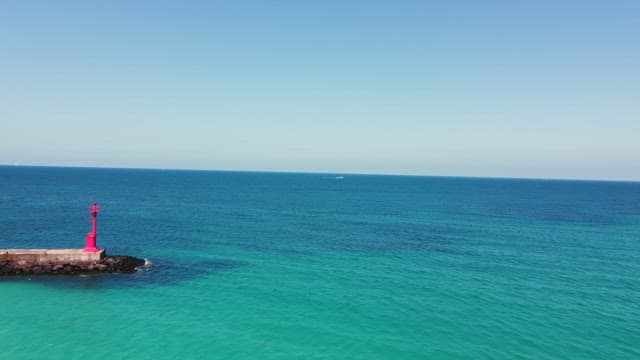 Calm sea with a red lighthouse