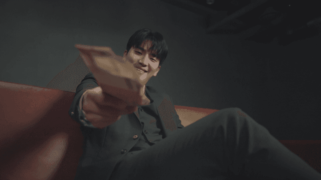 소파에 앉아 돈을 권하는 남성