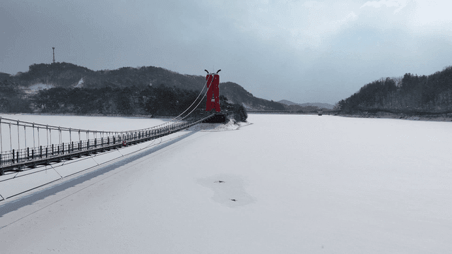 Snow-covered bridge over frozen lake