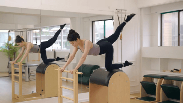 Woman exercising on a pilates barrel