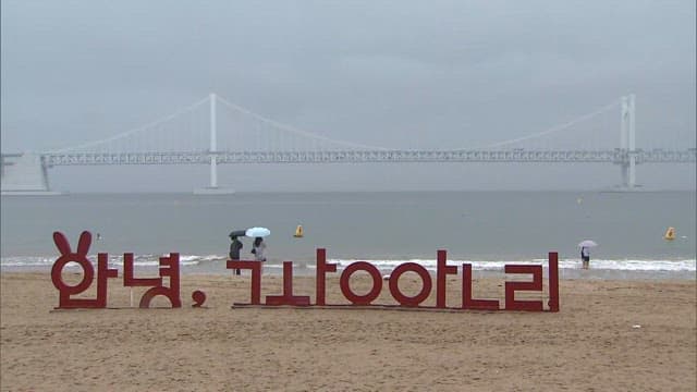 흐린 날, 멀리 다리가 보이는 해변