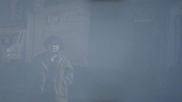 건물 밖에서 걱정스러운 표정으로 서 있는 여자