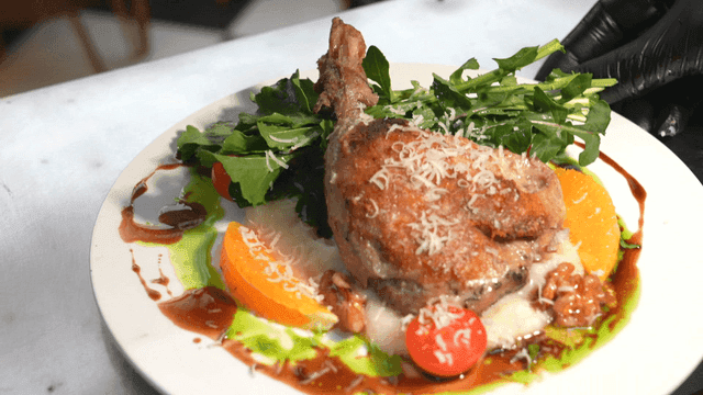Plate containing premium salad and duck confit