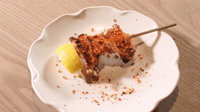 Grilled chicken wing skewers served on plate with lemon