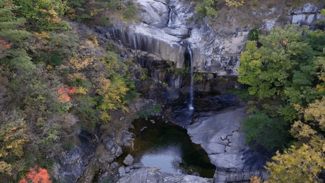 가을 단풍에 둘러싸인 경치 좋은 폭포