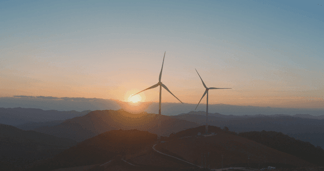 Wind turbines at sunrise over mountains