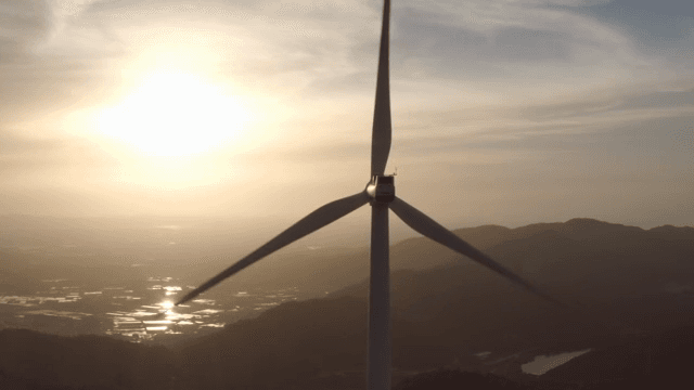 산 위의 풍력 터빈과 일몰