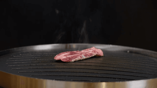 뜨거운 팬 위에서 고기를 굽는 장면