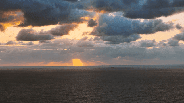 Sunset over the ocean with dramatic clouds