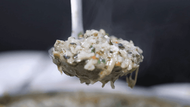 Ladle filled with steaming porridge