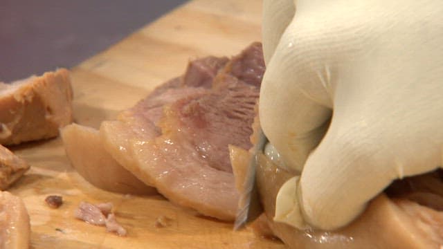 Slicing boiled pork on a cutting board