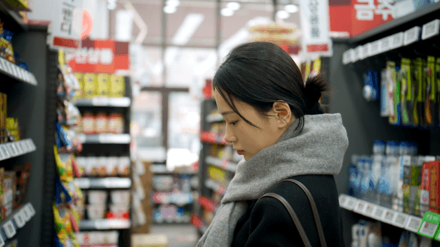 Woman choosing snacks in supermarket aisle