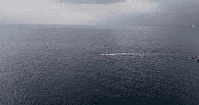 바위 해안 근처를 항해하는 보트