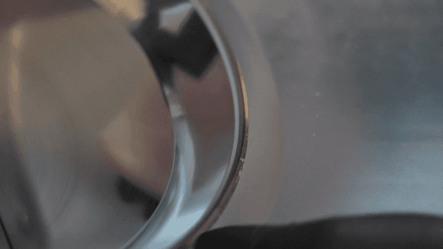 Hands cutting cold meat with meat slicer