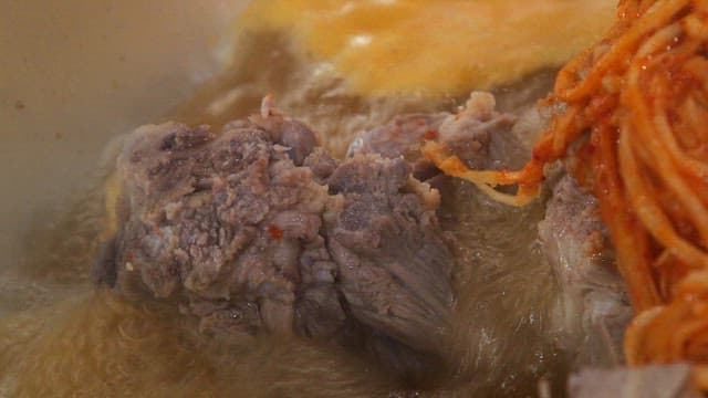 끓고 있는 고기와 양념된 무생채