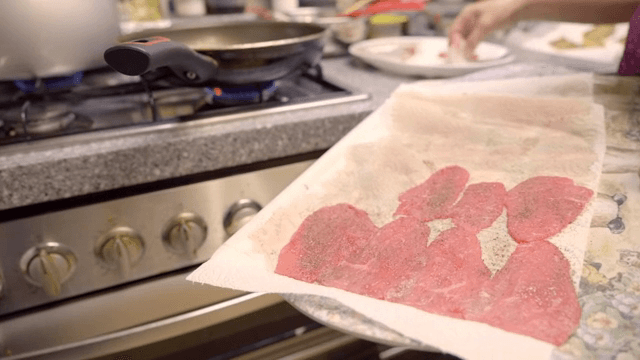 Preparing meat slices in a kitchen