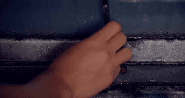 서리가 낀 창문을 여는 손