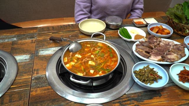 다양한 반찬과 수육, 찌개가 있는 맛있는 한국식 식사