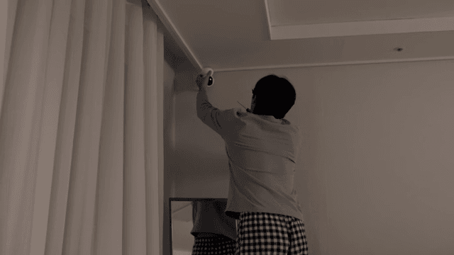 거실에 카메라를 설치하는 남자