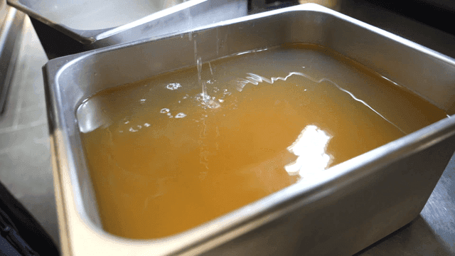 Clear broth filtered through cloth in kitchen