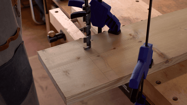 큰 드릴 비트로 나무를 뚫는 장면