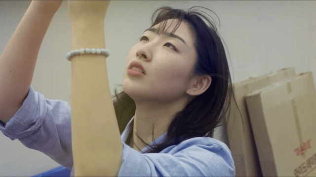 손을 뻗은 채 무언가를 바라보는 여성