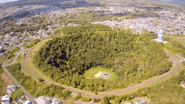 도시 근처 숲이 우거진 분화구의 항공 뷰
