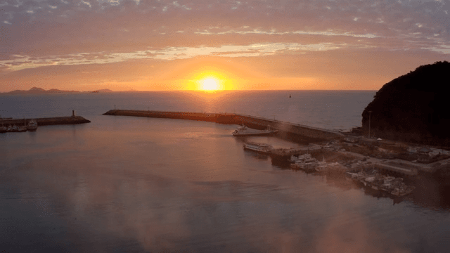 보트가 있는 고요한 항구의 일몰