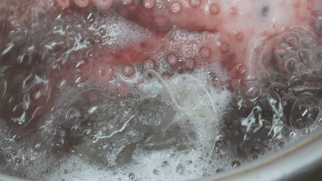 Octopus being boiled in tea bag broth pot