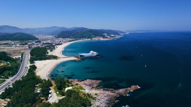 맑은 날 큰 배가 정박해 있는 해변가의 풍경