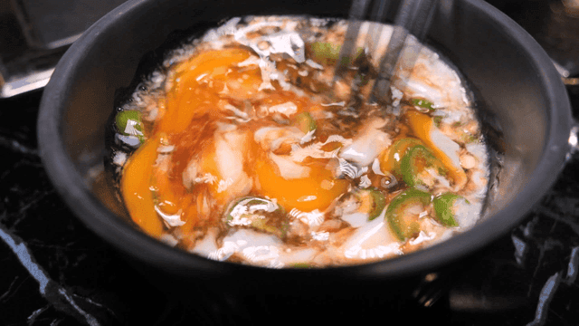 Soy sauce with egg and chili peppers, stirred with chopsticks
