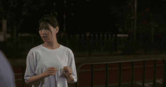 Two men fighting on street and woman watching