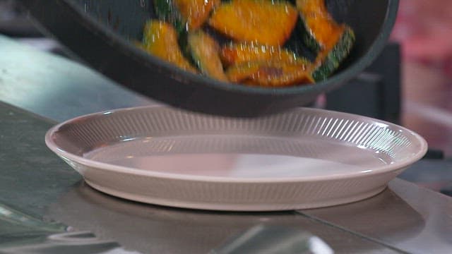 노릇노릇하게 구워진 단호박을 접시에 담는 장면