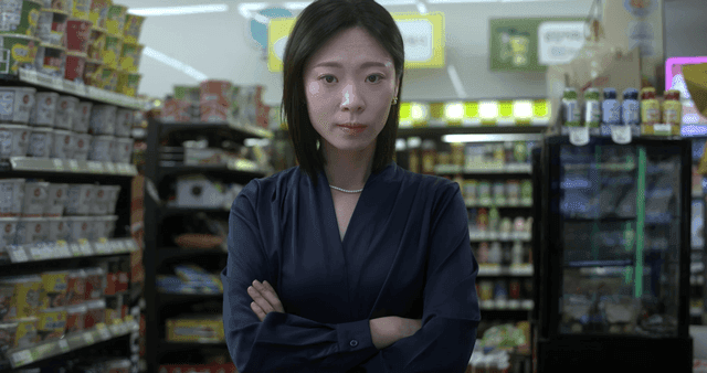Woman handing over card at convenience store
