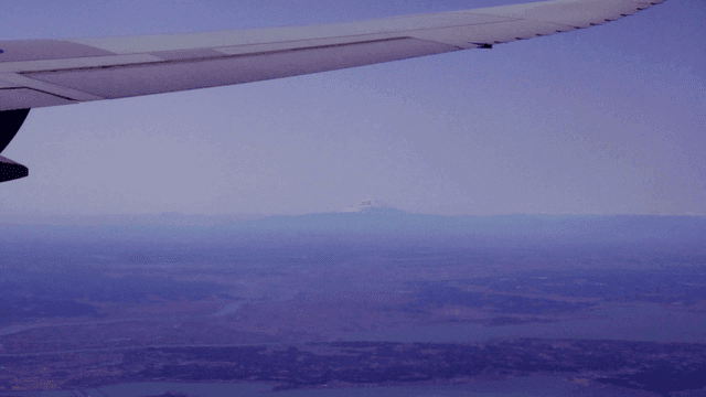 Airplane wing and Mount Fuji in distance