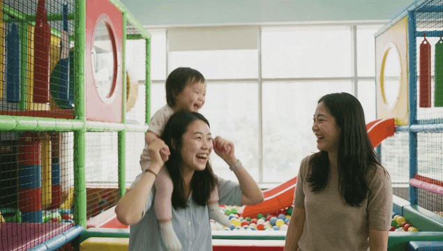 Indoor playground with child on hobby horse and women