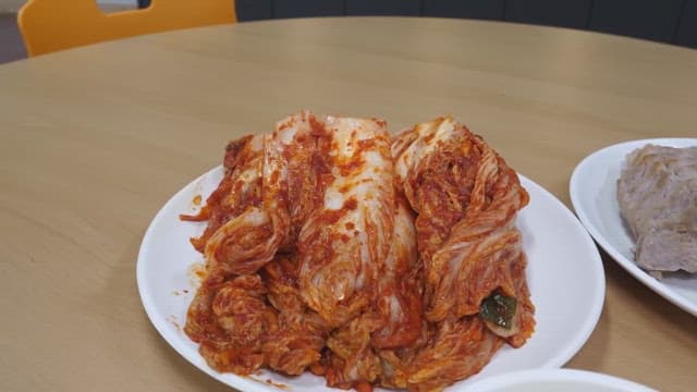 Chopstickful of traditional Korean cabbage kimchi with red seasoning