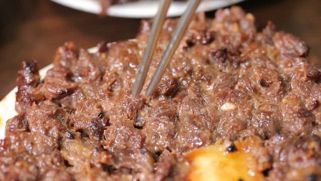 젓가락으로 집어드는 구운 소고기 떡갈비