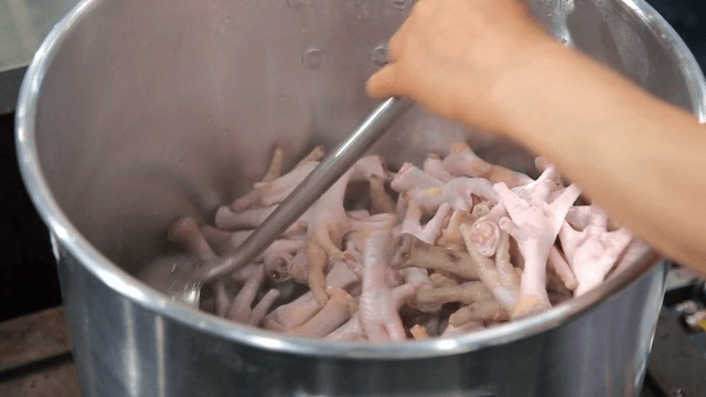 냄비에서 닭발을 저으며 조리하는 장면