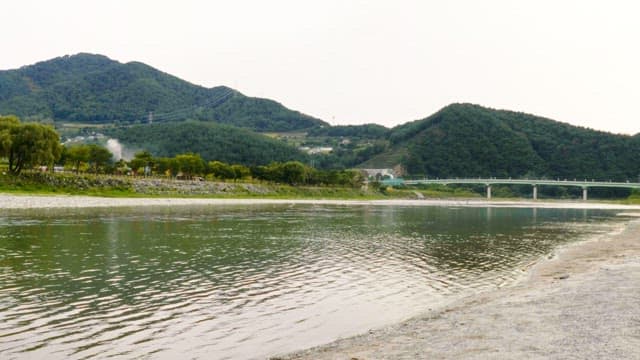 먼 초록 언덕이 있는 고요한 강변