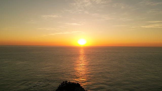 Sunset over the calm ocean horizon