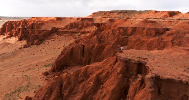 Red desert cliffs with scattered people