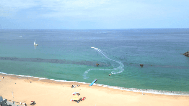 Serene beach with a yacht and jet skis