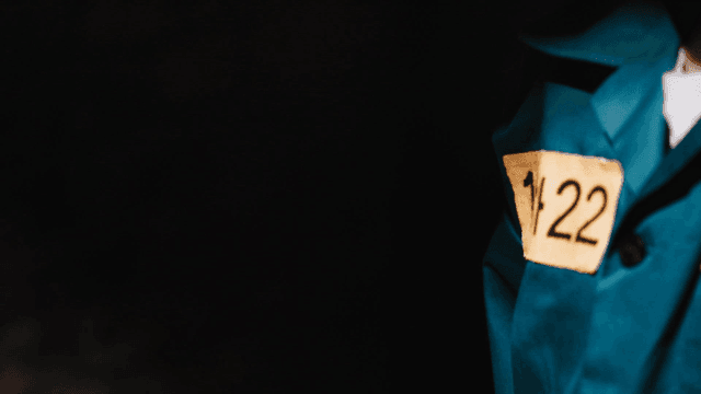 Prisoner wearing turquoise jumpsuit with number