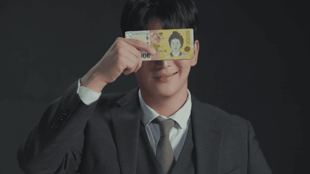 돈으로 얼굴을 가리며 상반된 표정을 보이는 남자