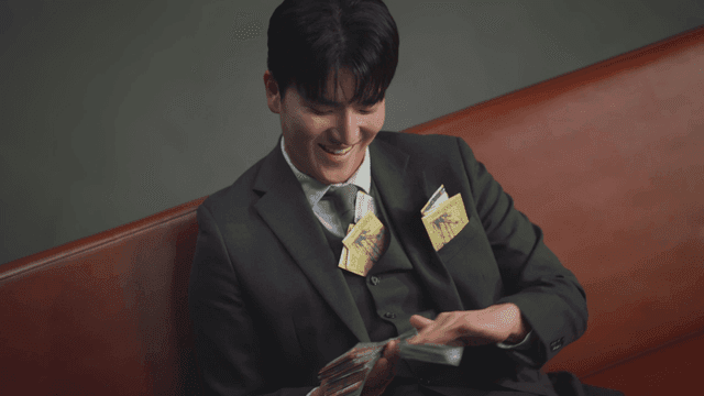 소파에 앉아 돈을 뿌리는 남성