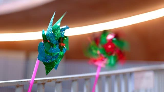 금속 펜스 앞에서 회전하는 화려한 바람개비